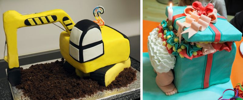 Finished cakes in the shape of an excavator and a baby stuck in a box head-first.